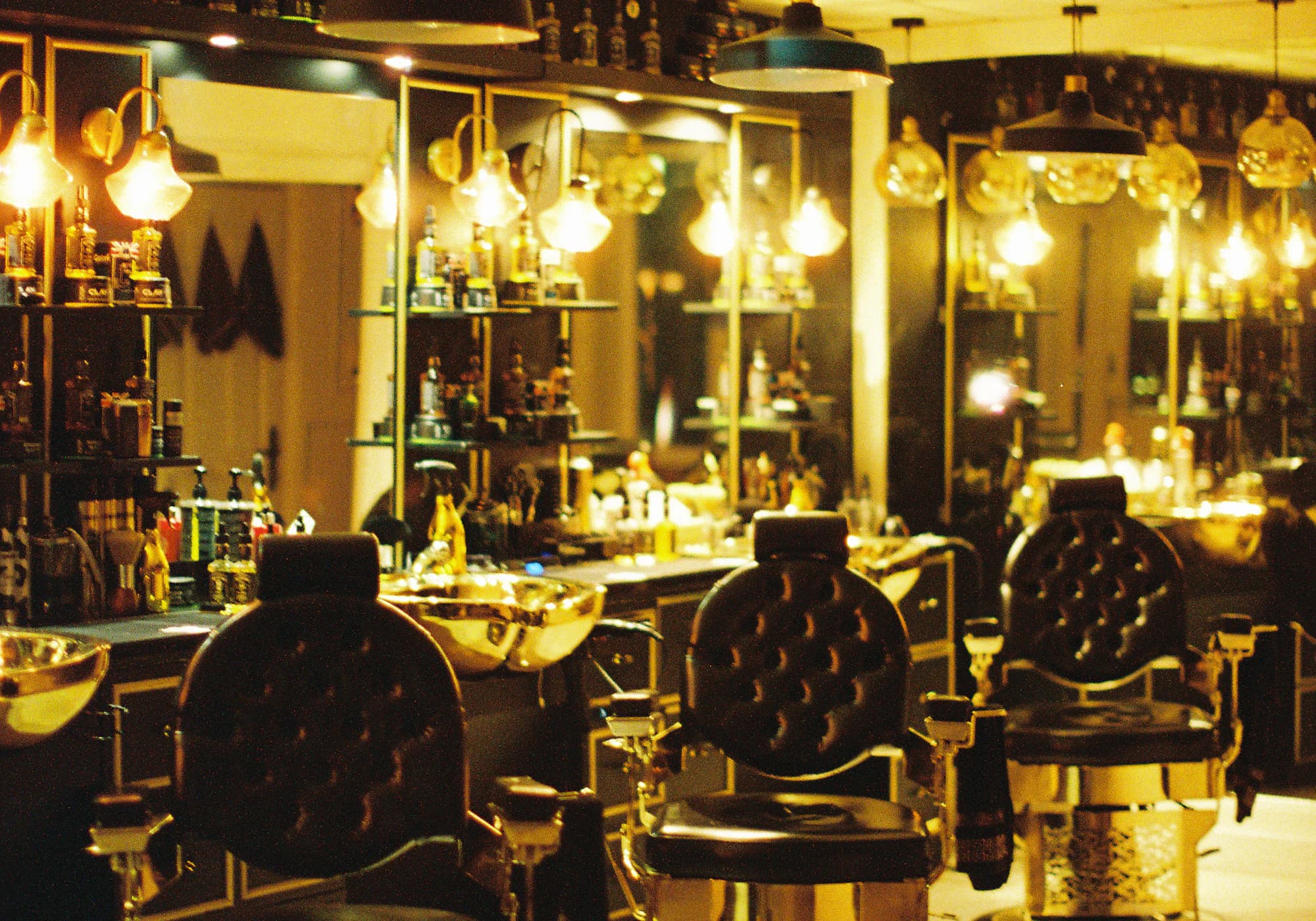 The Hair Xpressions salon floor at dusk, styling chairs lit low